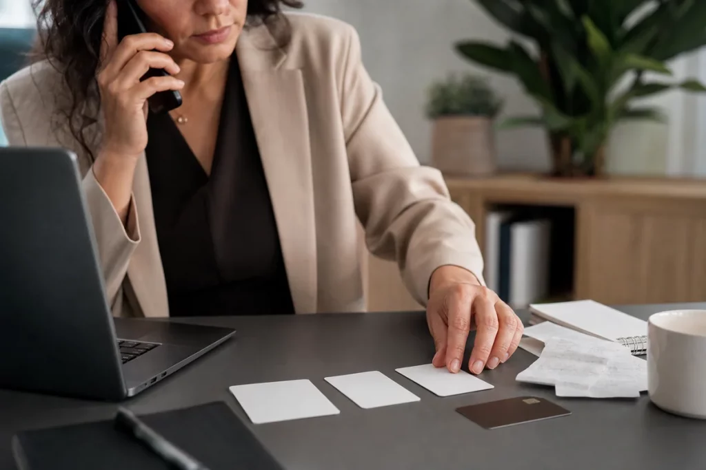 An adult calling a financial institution while organizing transaction records and scam messages at a secure desk.